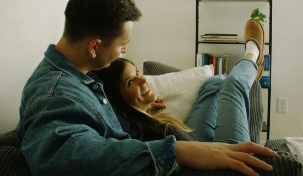 Couple sitting together on a sofa during a relaxed moment, representing couples counselling and relationship support.